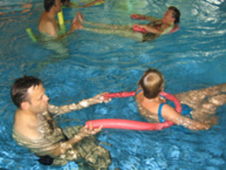 6 Personen bei Wassergymnastik mit Poolnudeln in Partnerübung